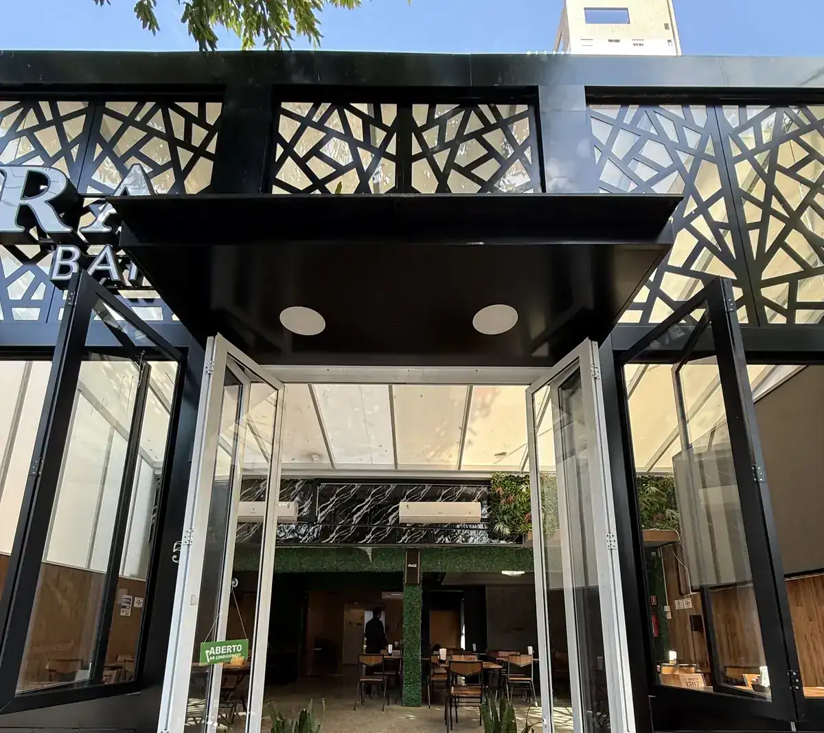 Fachada do Zora Bar na Rua Tolentino Filgueiras, no Gonzaga, em Santos, com portas sanfonadas abertas para a calçada