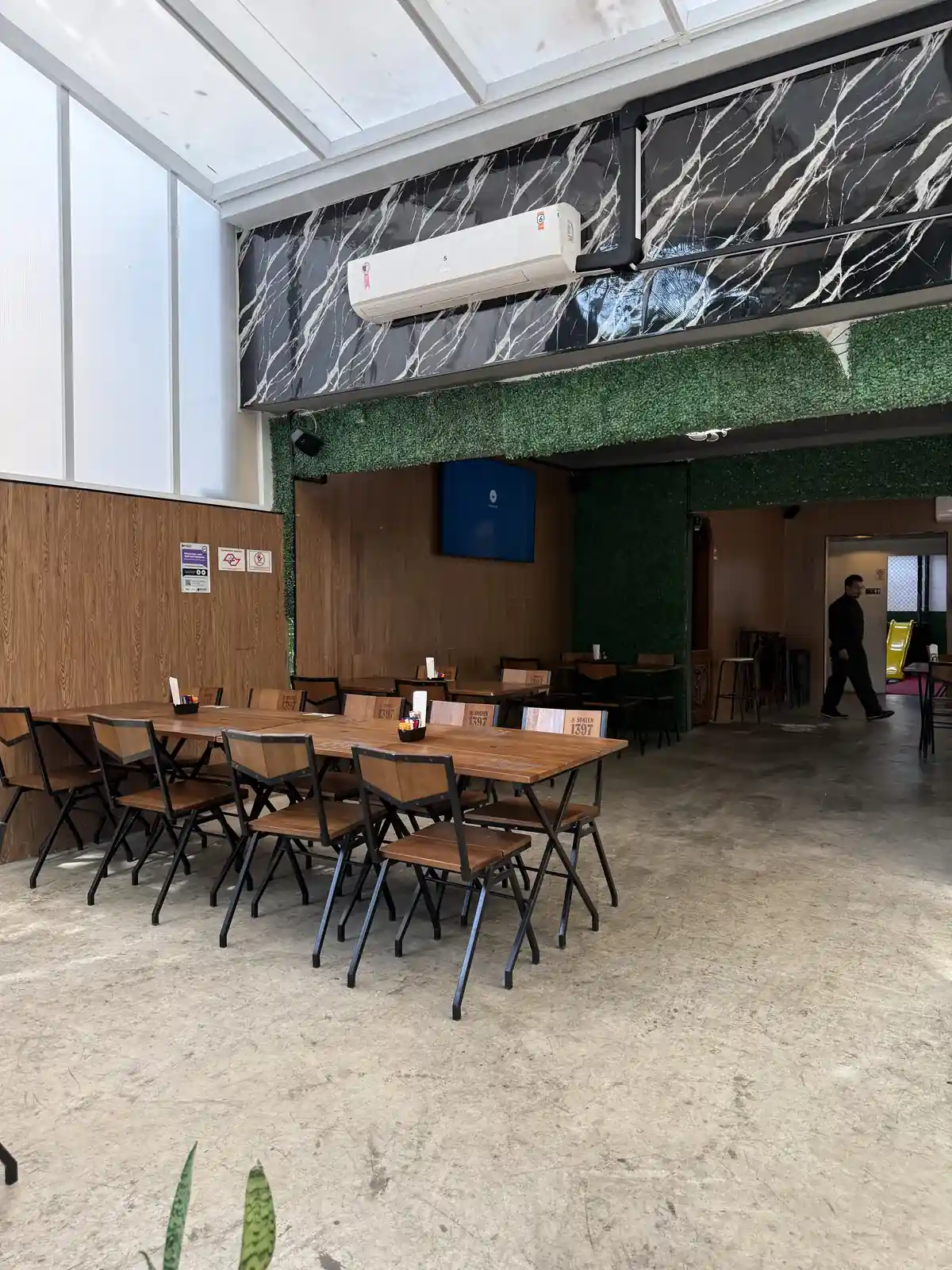 Mesas do salão do Zora Bar preparadas com cardápio e porta-guardanapos
