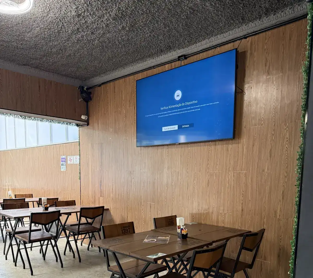Mesas do Zora Bar posicionadas em frente à TV do salão interno