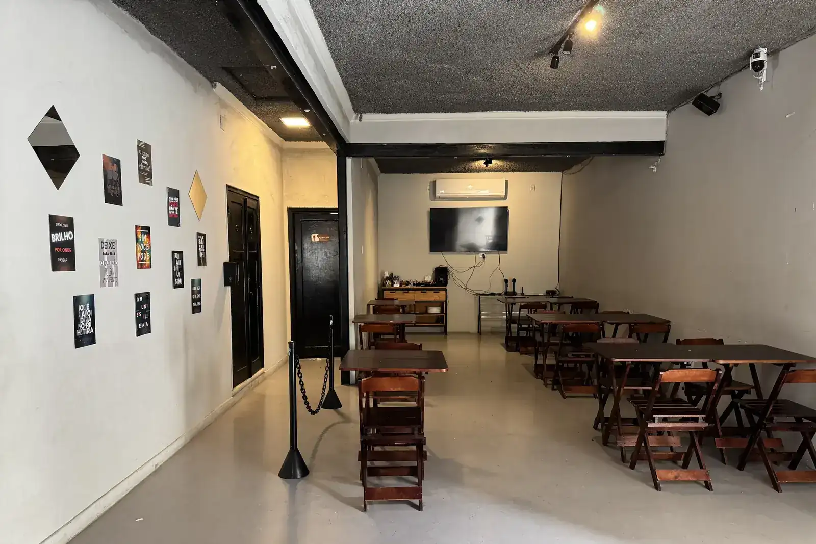 Salão de festas privativo do Zora Bar montado com mesas de madeira