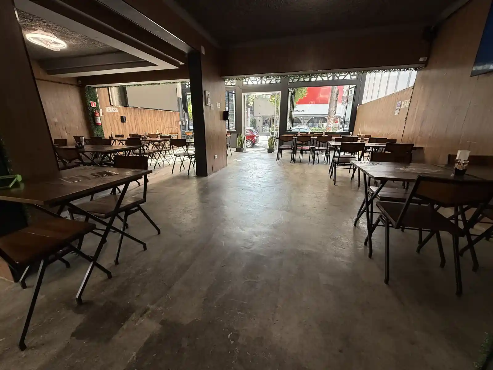 Salão amplo do Zora Bar durante o dia, com mesas de madeira e luz natural, no Gonzaga