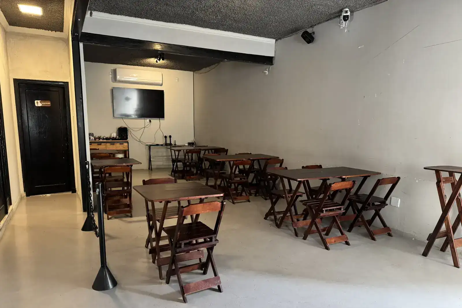 Salão com karaokê do Zora Bar preparado para receber grupos